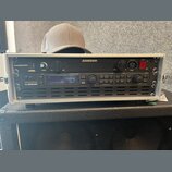 Stříbrný rackový case obsahuje dvě zařízení značky SAMSON. Horní jednotka má nápis PowerBrite PB10, ovládací prvky pro SHIMMER a LAMP a červený vypín…