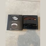 Fotografie zobrazuje snímač pro akustickou kytaru v originální černé krabici. Snímač má hnědé dřevěné provedení s nápisem kna a je vybaven černým kab…