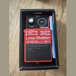 Červený kytarový pedál Boss Loop Station RC-1 v originální černé krabici s přiloženou dokumentací. Na horní části je ovládací knoflík LEVEL, tlačítko…
