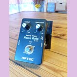 Černý kytarový efekt s nápisy Speedy Trigger Noise Gate a SE-NGT. Na horní straně jsou dva stříbrné ovratidla s popisky OUTPUT (Min, Max) a SENSITIVI…