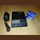 Černý přístroj s nápisy YAMAHA a MIDI DATA FILER MDF3, vybavený malým displejem a několika ovládacími tlačítky. Vedle přístroje je černý napájecí ada…