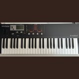 Černý klávesový syntetizátor s bílými a černými klávesami. V levém horním rohu je nápis blofeld SYNTHESIZER a v pravém dolním rohu logo waldorf. Přís…