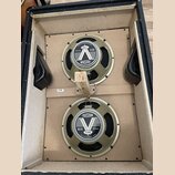 Fotografie zachycuje vnitřek černého reproduktorového boxu se dvěma zapuštěnými reproduktory. Na obou jsou viditelná loga a nápisy CELESTION, G12, TY…