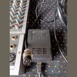 Černý síťový adaptér značky PHONIC s bílým štítkem. Na štítku je text: AC ADAPTOR, P/N: 353-21904-000-0, INPUT: 230V AC 50Hz, OUTPUT: 16.8Vx2 AC 1A a…