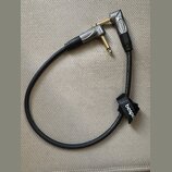 Černý instrumentální kabel s pozlacenými konektory a šedými kovovými kryty. Na obou konektorech i na černém suchém stahovátku je uveden nápis bespeco…