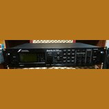 Černý rackový procesor s nápisy FRACTAL AUDIO SYSTEMS a Axe-Fx II PREAMP/ FX PROCESSOR. Na předním panelu je displej, ovládací knoflíky a tlačítka s…
