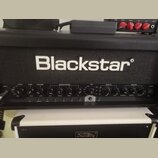 Černý kytarový kombozesilovač značky Blackstar. Na předním panelu jsou nápisy V-VOICE, GAIN, VOLUME, EQUALISATION, TVP, EFFECTS a MASTER, dále označe…
