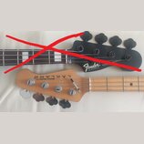 Fotografie zobrazuje dvě hlavy basových kytar. Horní černá hlava nese logo Fender, nápis DELUXE MADE IN MEXICO a sériové číslo MXD1901226, přičemž je…