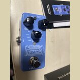 Modrý efekt pedál s nápisy Drum&Loop a logem HOOK. Zařízení má tři černé otočné ovladače s popisky LOOP LEVEL, DRUM LEVEL a STYLE, dále tlačítko Smar…