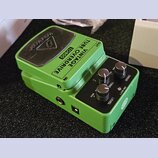 Zelený kytarový efekt s černým ovládacím panelem a černým spínacím pedálem. Na horní části je nápis VINTAGE TUBE OVERDRIVE TO800 a na pedálu logo tec…
