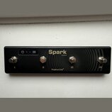 Černý ovladač s čtyřmi kovovými spínači, které jsou podepsány římskými číslicemi I, II, III a IV. Na horní části je nápis Spark Control a v dolní čás…