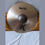 Kulatý činely v bronzové barvě s kovaným povrchem. Na horní části je černý nápis SWEET CRASH a pod ním údaj 19"/48 cm. Ve spodní části je velké černé…