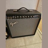 Černý kytarový kombo zesilovač s šedou síťovinou. Na předním panelu je nápis Fender a v pravém horním rohu označení Champion 40. Ovládací panel obsah…