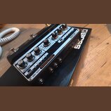 Černý efekt pedál s kovovým horním panelem. Na panelu je nápis Delay Machine DM-101 a logo BOSS. Jsou zde vidět ovládací knofíky, přepínače a konekto…