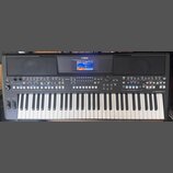 Černý digitální klavír značky YAMAHA s modelem PSR-SX600. Nástroj má v horní části displej a dvě integrovaná reproduktory s mřížkou. Ovládací panel o…
