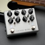 Stříbrný efekt pedál s osmi černými ovládacími knoflíky. Na spodní části je nápis VINTAGE ULTRA a pod ním menším písmem DARKGLASS ELECTRONICS - MADE…