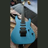 Modře lakovaná elektrická kytara s černým hardwarem a třemi snímači. Na každém ze snímačů je bílý nápis Seymour Duncan. Na hlavě hmatníku je viditeln…