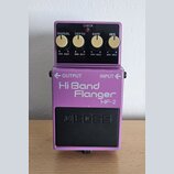 Fialový kytarový efekt s nápisem Hi Band Flanger HF-2 a logem BOSS na černém spínacím pedálu. Horní panel obsahuje čtyři zlaté otočné knoflíky s popi…