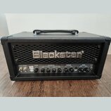 Černý kytarový kombo zesilovač s koženým potahem a kovovou mřížkou. Na mřížce je umístěno stříbrné logo Blackstar. Ovládací panel obsahuje přepínače…