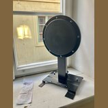 Černý cýrní pad značky Gibraltar s nápisem PRACTICE PAD, umístěný na černé kovové základně. Pad je kruhový a upevněn šesti šrouby k vnějšímu rámu. Ve…