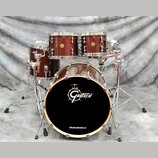 Bubnová sada v tmavě hnědé barvě s texturou dřeva a chromovaným kováním. Na přední bláně basového bubnu je bílé logo Gretsch a nápis DRUMCENTER.CZ. S…