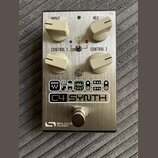 Kytarový efekt v kovovém šasi stříbrné barvy s nápisem C4 SYNTH a logem SOURCE AUDIO. Zařízení má čtyři bílé otočné knoflíky s popisky INPUT SENSE, M…