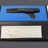 Černý dynamický mikrofon s mřížkou a držákem, na těle kterého je nápis SENNHEISER. Pod mikrofonem je papírový certifikát s nápisy SENNHEISER electron…