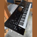 Černý digitální klavír s bílými a černými klávesami. Na ovládacím panelu je umístěn displej a logo YAMAHA. Nástroj obsahuje množství tlačítek, posuvn…