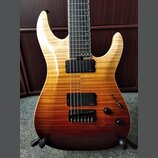 Elektrická kytara s tělem v žlutě-hnědém gradientu a plamenovitou strukturou dřeva. Nástroj má dva černé humbuckery, z nichž oba nesou nápis "Presici…