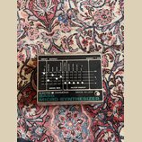 Stříbrný efektový pedál s černým ovládacím panelem. Na spodní části je nápis ELECTRO HARMONIX MADE IN USA BASS MICRO SYNTHESIZER. Panel obsahuje něko…