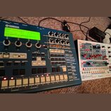 Modrý sekvenční modul s nápisy YAMAHA a RM1x SEQUENCE RECORDER MIXER. Zařízení má zelený podsvícený displej, několik otočných knoflíků a bílé orazvác…