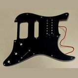 Černý plastový pickguard pro elektrickou kytaru s jedním instalovaným humbuckerem. Z povrchu jsou viditelné drobné škrábance a stopy používání, z nás…