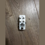 Bílý kytarový efekt pedál s nápisy ehx, DEEP FREEZE a NYC DSP. Na horní straně jsou čtyři bílé otočné oválné knoflíky s popisky MODE, DRY, EFFECT a S…