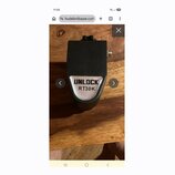 Černý kytarový pedál s kovovým štiťkem. Na přední straně je stříbrný štítek s nápisem UNLOCK RT30K. Povrch je matně černý, v horní části je vidět kno…