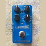 Modrý efekt pedál s nápisem FLASHBACK DELAY AND LOOPER a logem tc electronic. Obsahuje tři černé otočné ovladače s popisky Y, FEEDBACK a LEVEL oraz p…