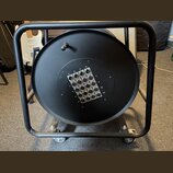Černý kabelový navíjač na kolečkách s kovovým rámem. Uprostřed je panel s 16 konektory typu XLR, které jsou rozděleny do čtyř sloupců označených písm…