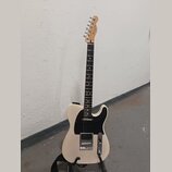Elektrická kytara s bílým tělem, černým pickguardem a hnědým hmatníkem. Na hlavě je viditelné logo Fender. Nástroj má jeden humbucker v pozici mostu…