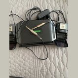 Sada bezdrátového mikrofonního systému značky SHURE v černé barvě. Na centrálním zařízení je zelený nápis SURE, vedle něj jsou dva zlaté konektory. V…