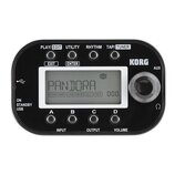 Černý kytarový procesor značky KORG s LCD displejem, na kterém je nápis PANDORA a hodnoty DYNA, AMP, CAB, MOD, DLY, REV a číslo 000. Zařízení má v ho…