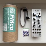 Bílý modul syntetizátoru s nápisem FMco, který obsahuje několik otočných potenciometrů a konektory. Na panelu jsou viditelné popisky: Freq, W/Oct, Lo…