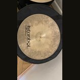 Kruhová činely z mosazi v přirozené zlatavé barvě s viditelným broušením. Na povrchu je černý nápis „istanbul Mehmet Handmade Cymbals from Turkey“. V…