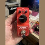 Červený kytarový efekt pedál s nápisem PHASER MINI. Na horní straně jsou dva malé černé otočné oválky s popisky DEPTH a F.BACK, velký černý ovládací…