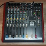 Míchací pult s červeným šasi a šedým ovládacím panelem. Na pravé straně je vidět logo ZED SIXTY 10FX a v dolní části nápis ALLEN&HEATH. Zařízení obsa…