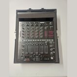 Černý mixovací pult značky RELOOP s označením JMH-40 DSP umístěný v přepravním kufru. Zařízení obsahuje čtyři kanály s rovnovážnými posuvníky, knoflí…