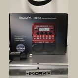 Červený basový efektový procesor Zoom B1 FOUR v originální krabici. Na zařízení jsou viditelné nápisy „B1 FOUR“, „ZOOM“ a „Multi-Effects Processor“.…