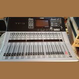 Digitální mixovací pult stříbrné a černé barvy. Na horním černém panelu jsou nápisy YAMAHA a TF3, displej a ovládací prvky. Spodní stříbrná část obsa…