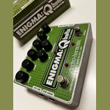 Zelený efekt pedál s nápisem ENIGMA:Qballs for Bass a značkou electro-harmonix MADE IN NYC, USA. Zařízení má osmi černých otočných knoflíků a dva sto…