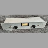 Bílý rackový kompresor s nápisy TUBE COMPRESSOR/LIMITER 1000 a ANTHONY DEMARIA LABS. Na předním panelu se nachází VU metr s označením ADL 1000, dva č…