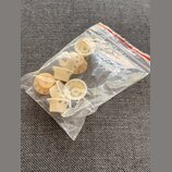 Průhledný plastový sáček s několika kroužkovými knoflíky z bílého nebo krémového plastu. Některé knoflíky mají na horní straně vyryté čísla 2, 6, 8 a…