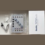 Modul syntezátoru v bílém provedení s nápisem QUAD LOPASS GATE MODEL 2921 a BUCHLA & TIPTOP AUDIO. Modul obsahuje čtyři modré otočné knoflíky, několi…